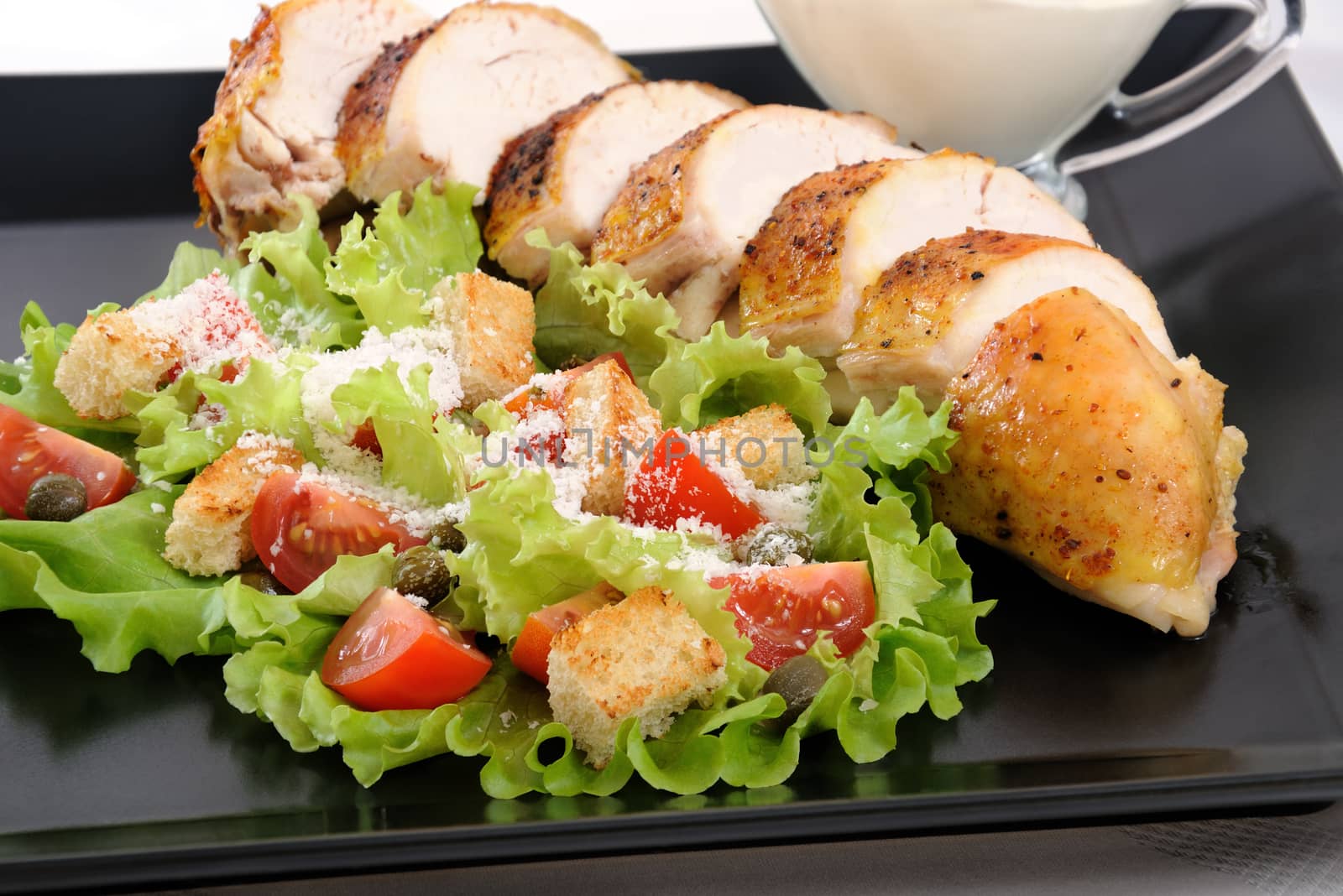 Sliced baked chicken breast with garnish  a la Caesar. 