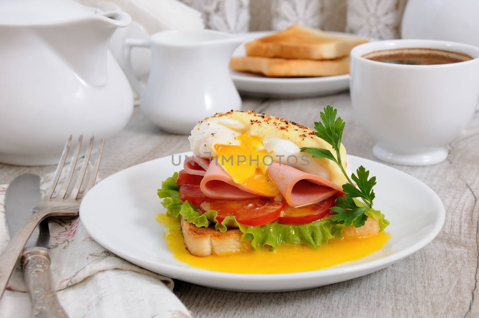 Toast with slices of ham and tomatoes, Benedict egg with Dutch sauce for Breakfast