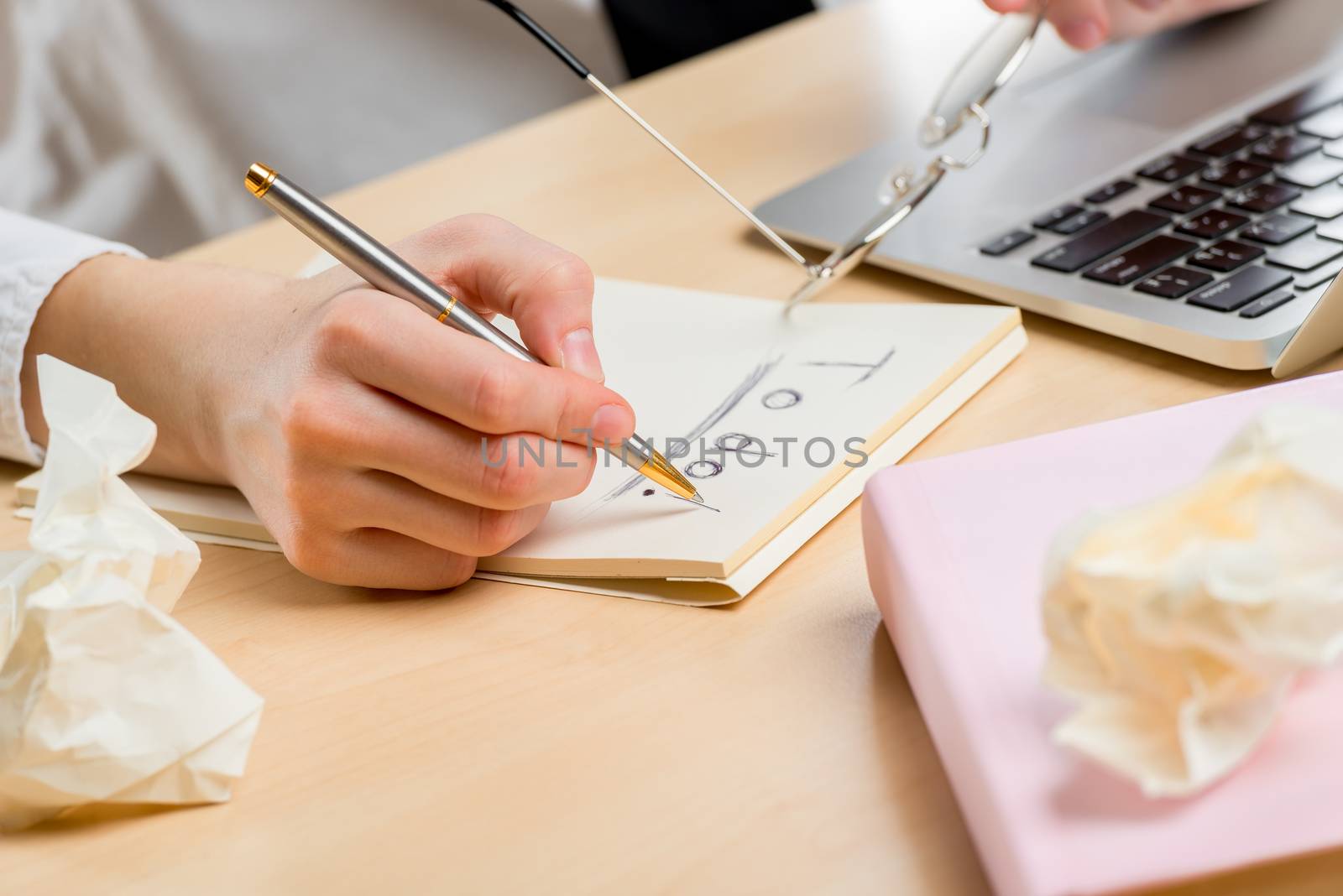 focus on hand holding pen and making a note pad