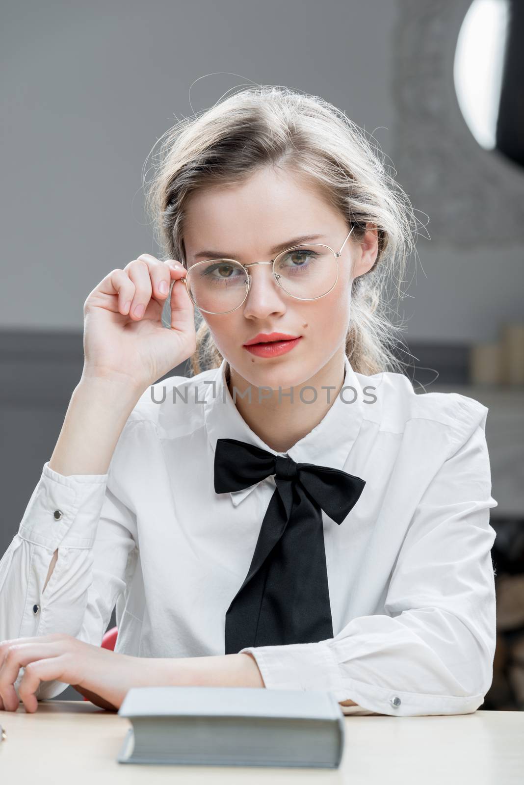 vertical portrait of a beautiful girl in stylish glasses sitting by kosmsos111