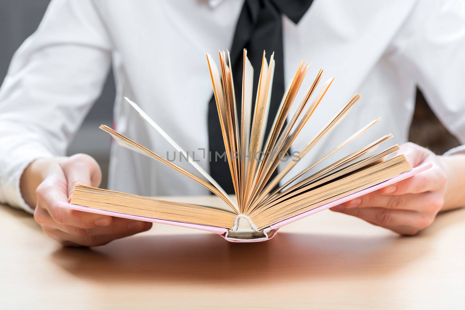thick book in the hands of a woman on a close-up table