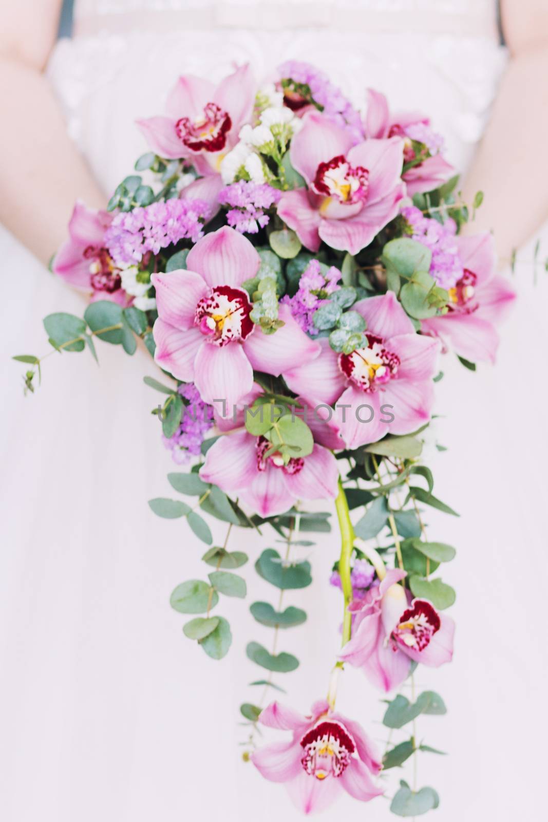 Wedding bouquet in the hands of the bride. Round wedding bouquet of pink flowers.