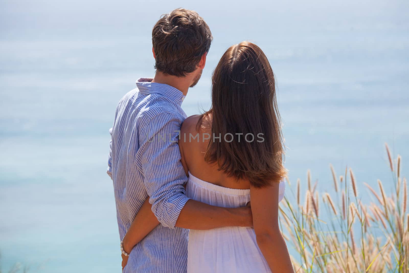 Young couple on vacation looking at sea together