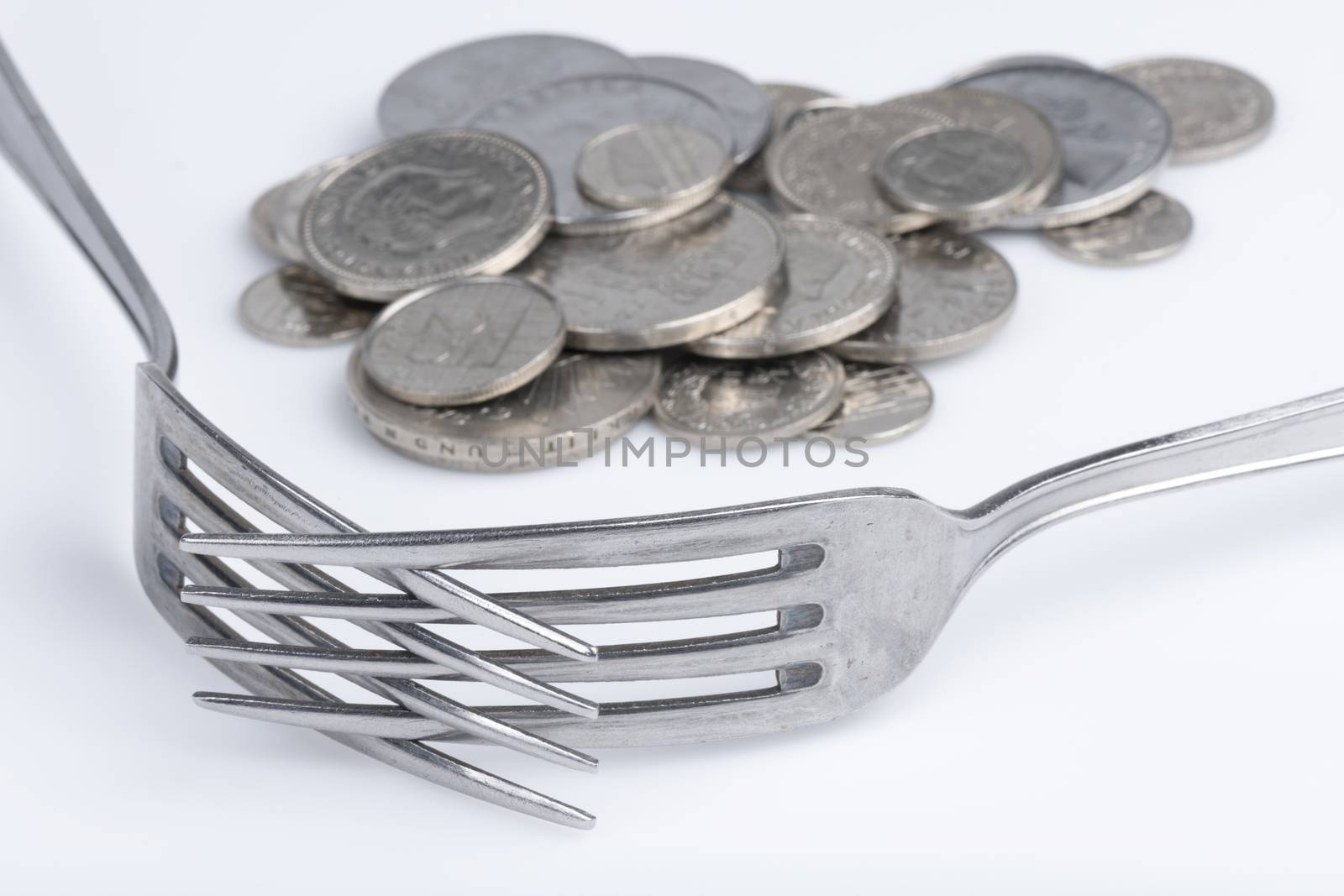 Conceptual representation of financial greed by two forks and coins
