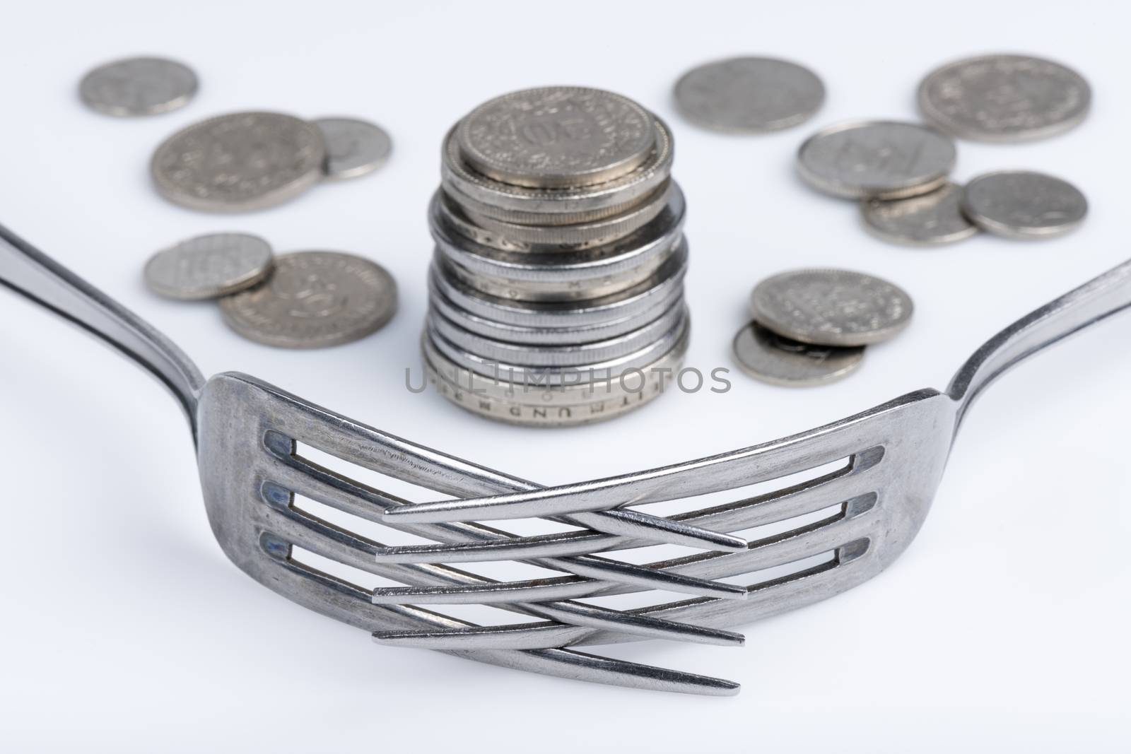 Conceptual representation of financial greed by two forks and coins
