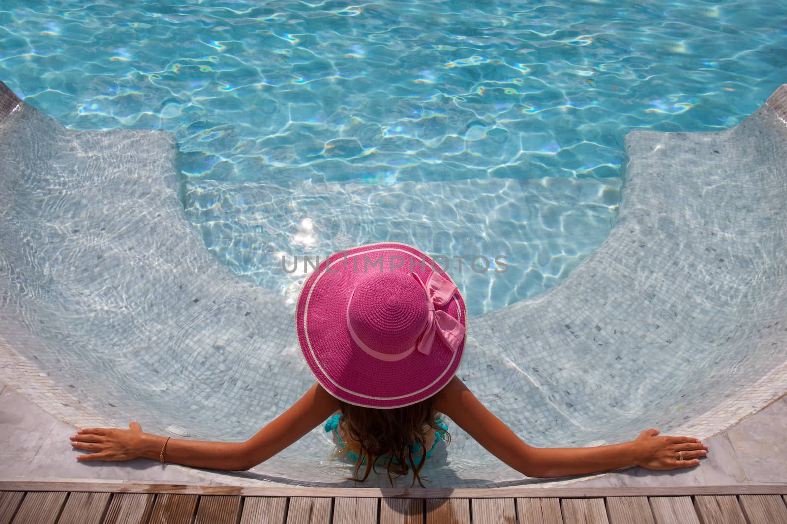 Beautiful woman relaxing at swimming pool at tourist resort