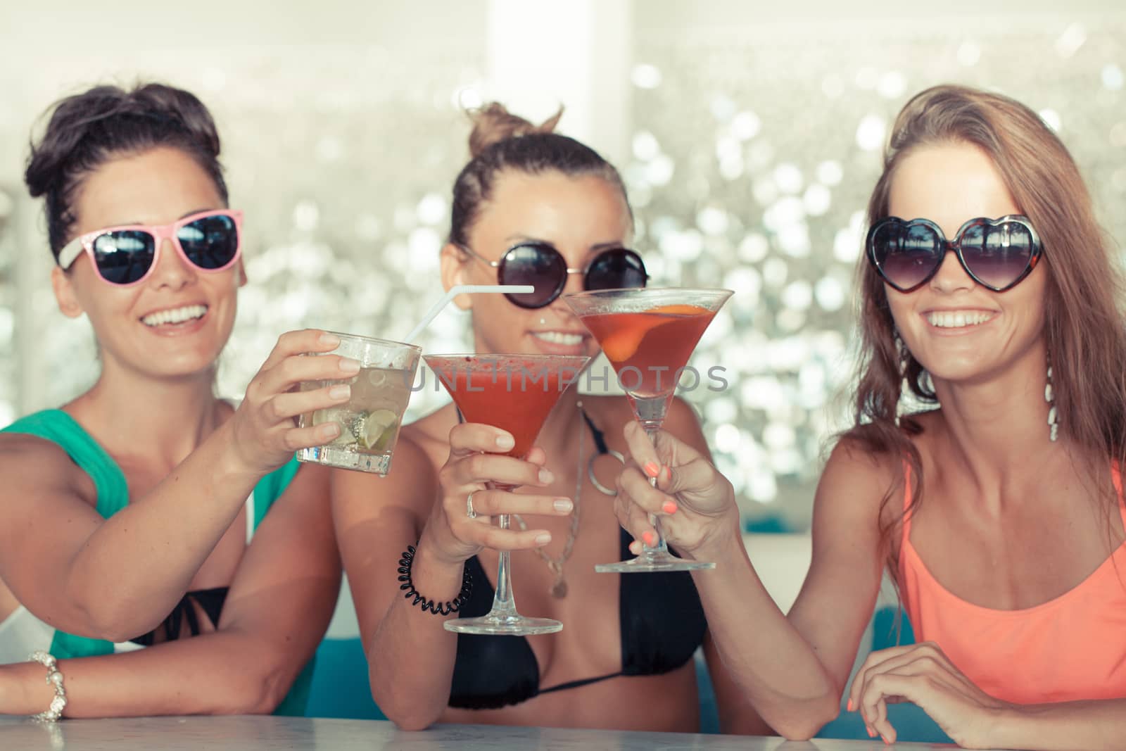 Happy young women with beverages having fun in cafe