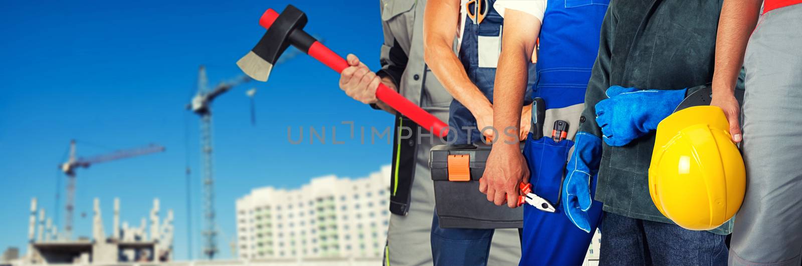 Many workers closeup with equipment on building background