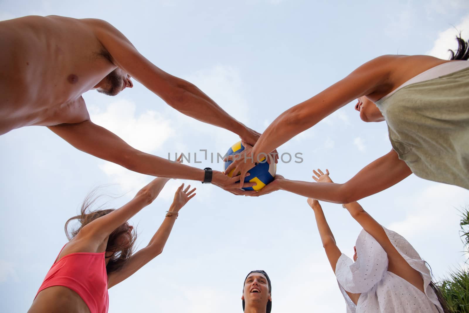 Group of young people playing volleyball outdoors
