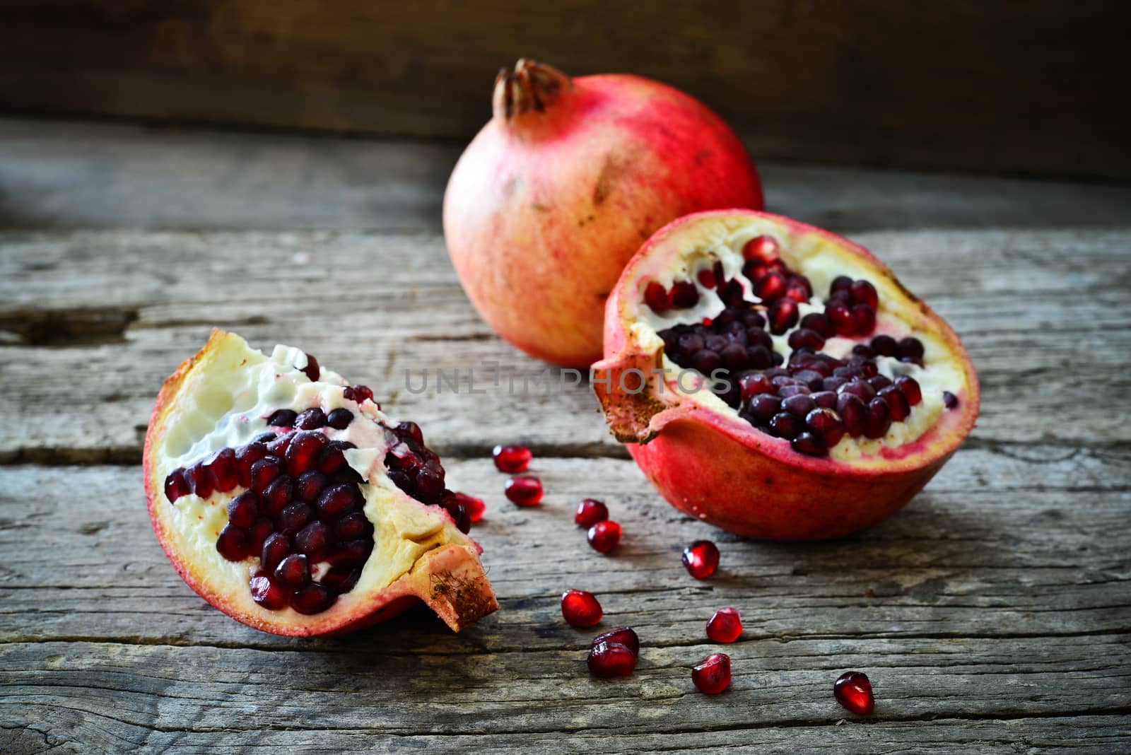 closeup of a pomegranate on a rustic wooden table