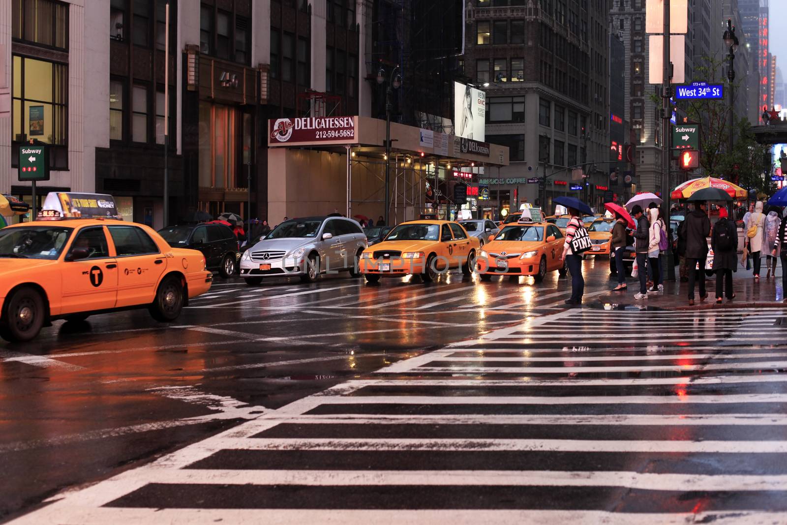 New York, USA - May 20, 2013: taxi's crossing at Time Square at night in the rain. The site is regarded as the world's most visited tourist attraction with nearly 40 million visitors annually.