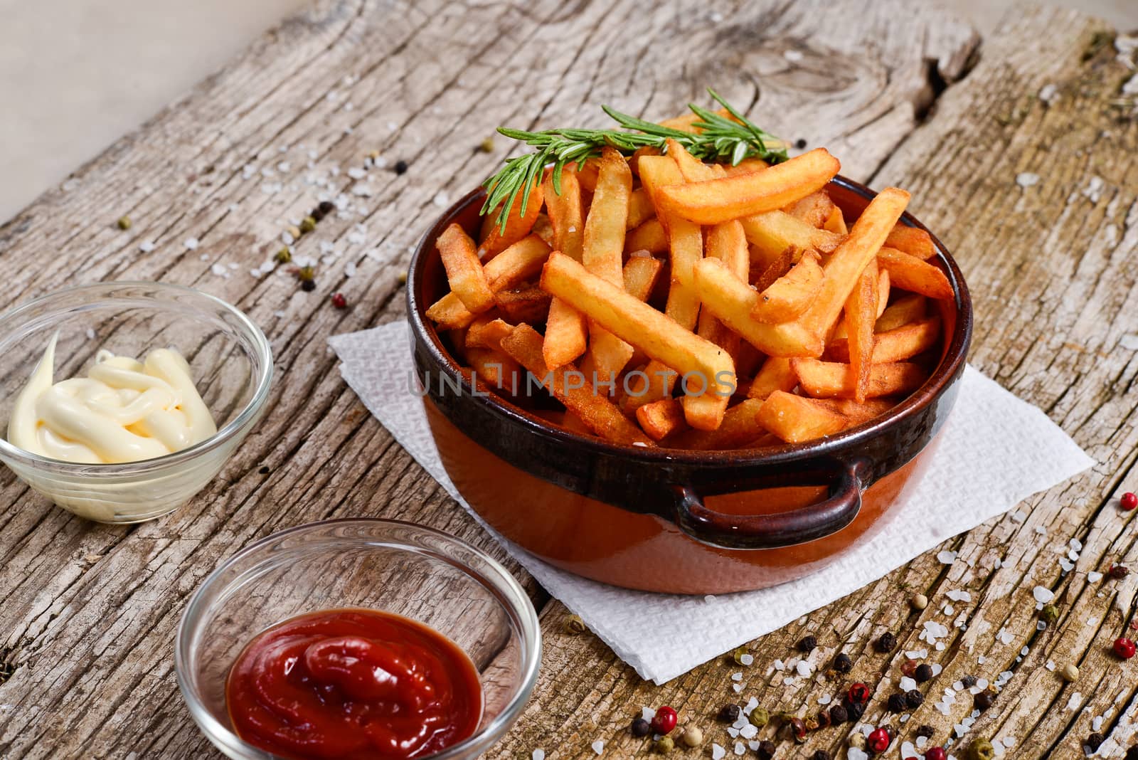 bowl of chips with salt and pepper on a wooden rustic.