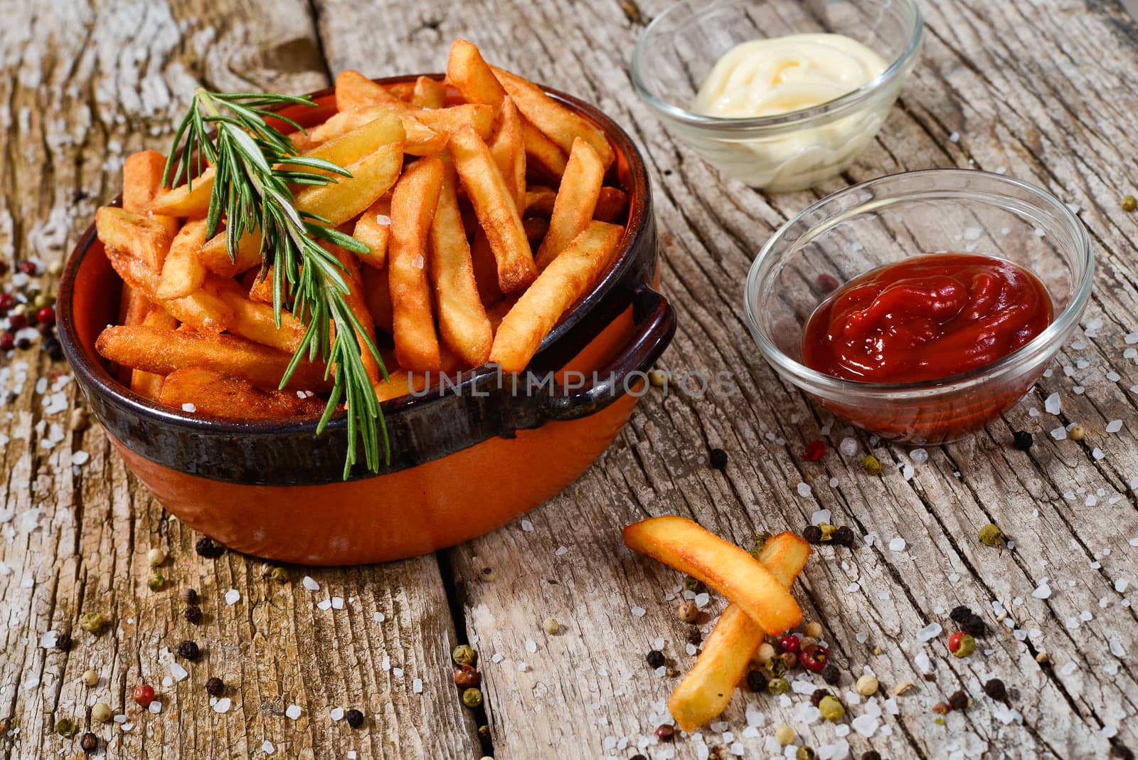 bowl of chips with salt and pepper on a wooden rustic.