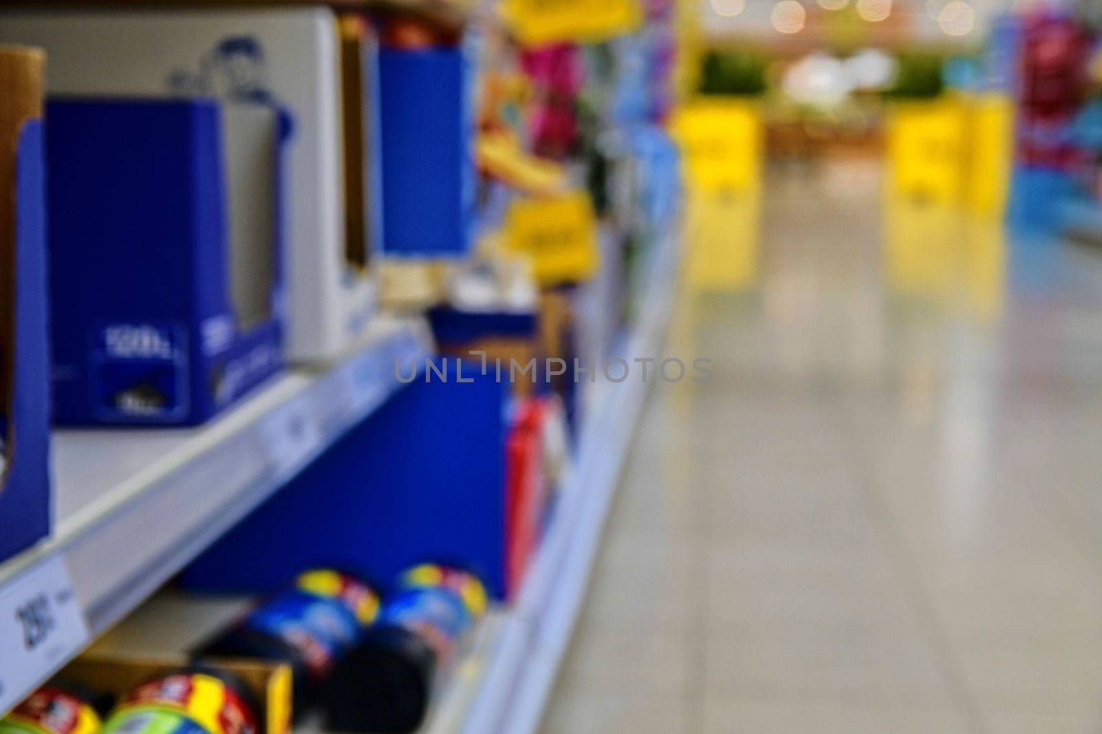 Blurred section at retail store in Europe. Aisle in local supermarket, defocused background.