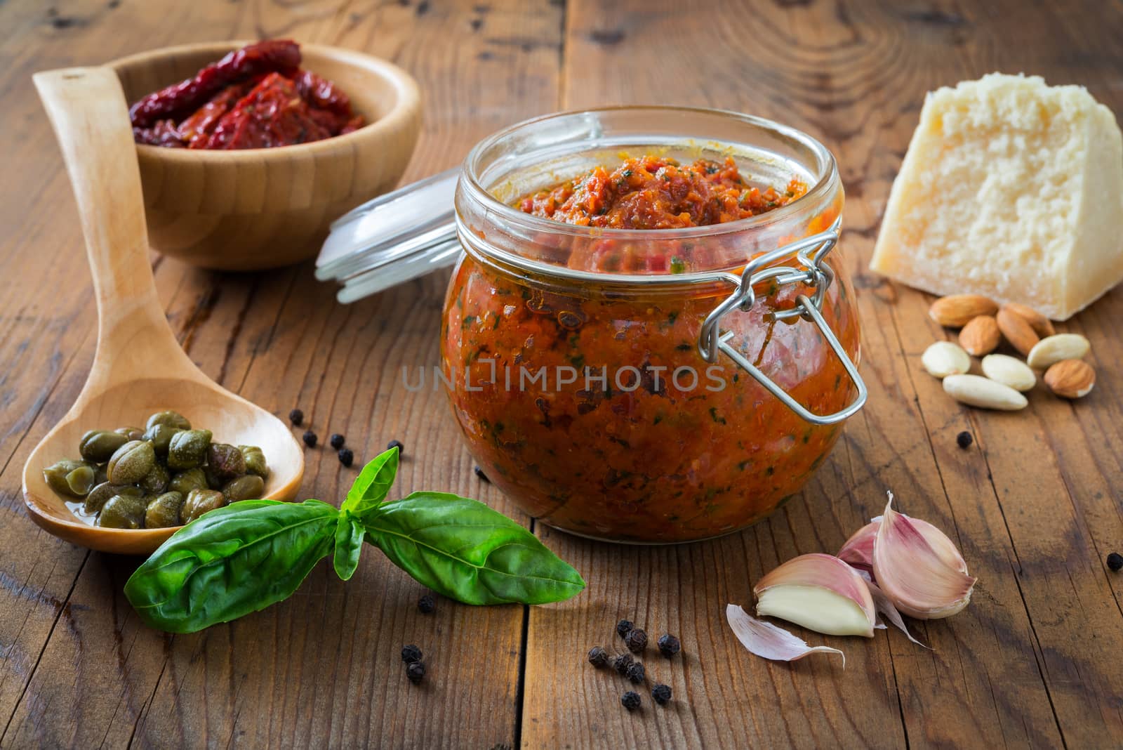 Pesto of parsley and almonds in a glass jar on a wooden table