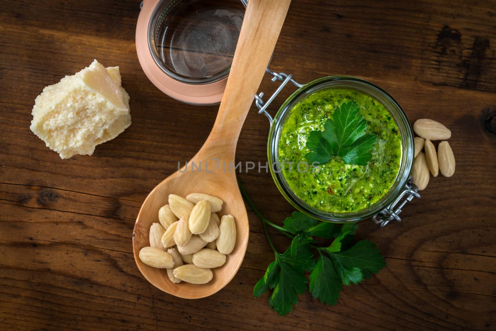 Pesto of parsley and almonds in a glass jar on a wooden table
