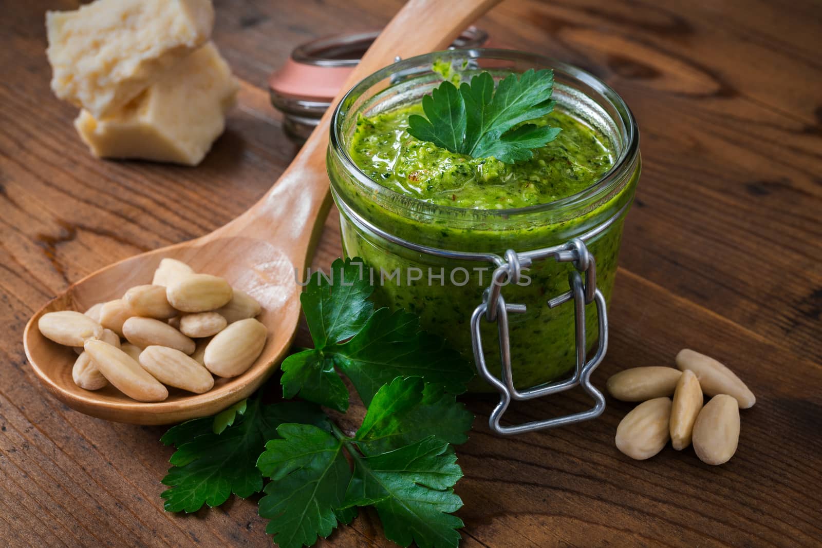 Pesto of parsley and almonds in a glass jar on a wooden table