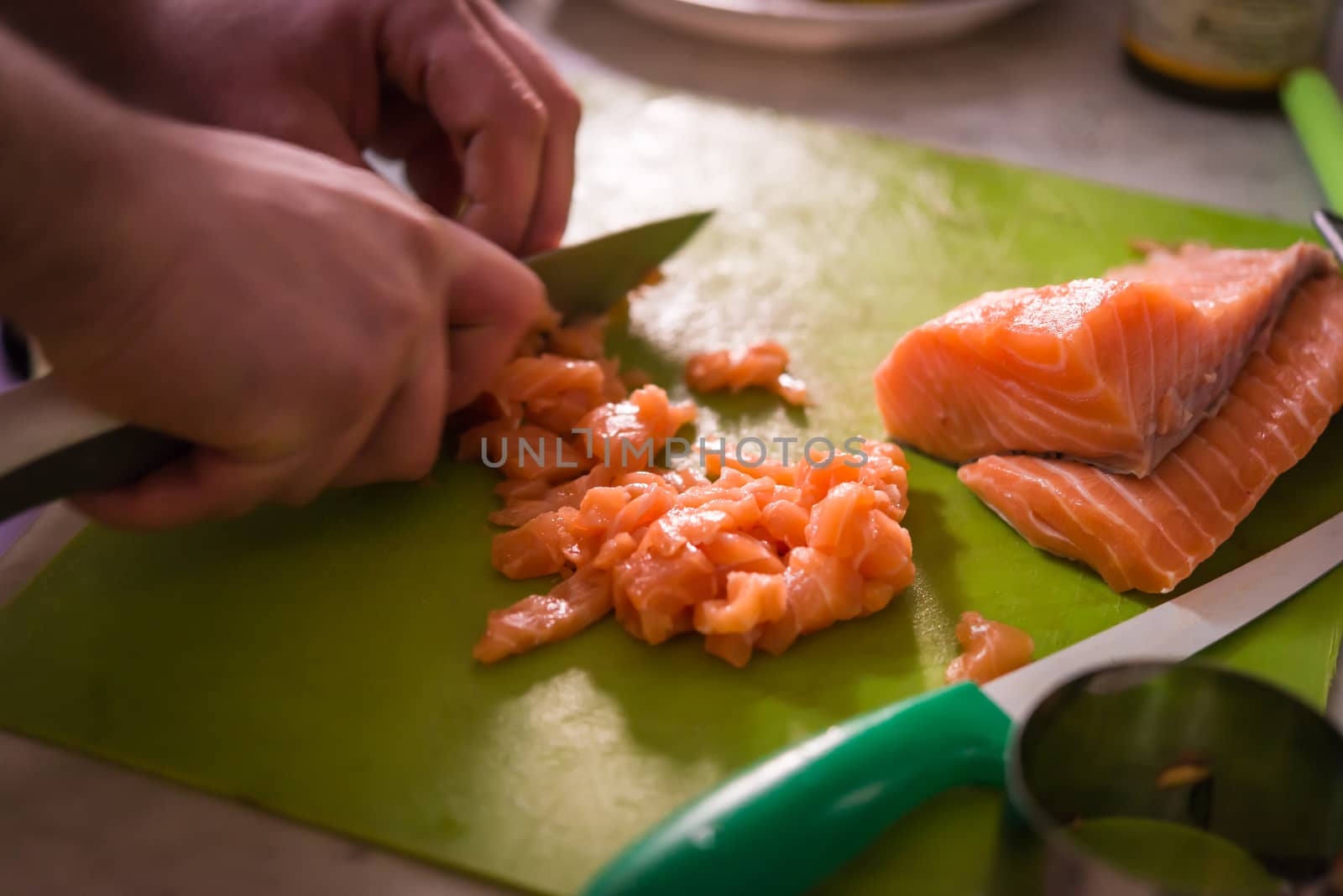 Chef slicing a raw fresh salmon fillet for sushi