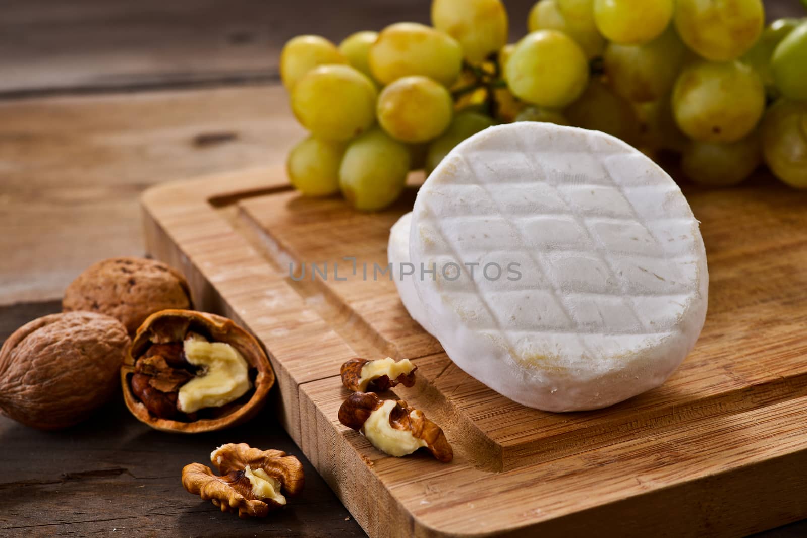Italian tomino cheese on a wooden chopping board, italian appetizer