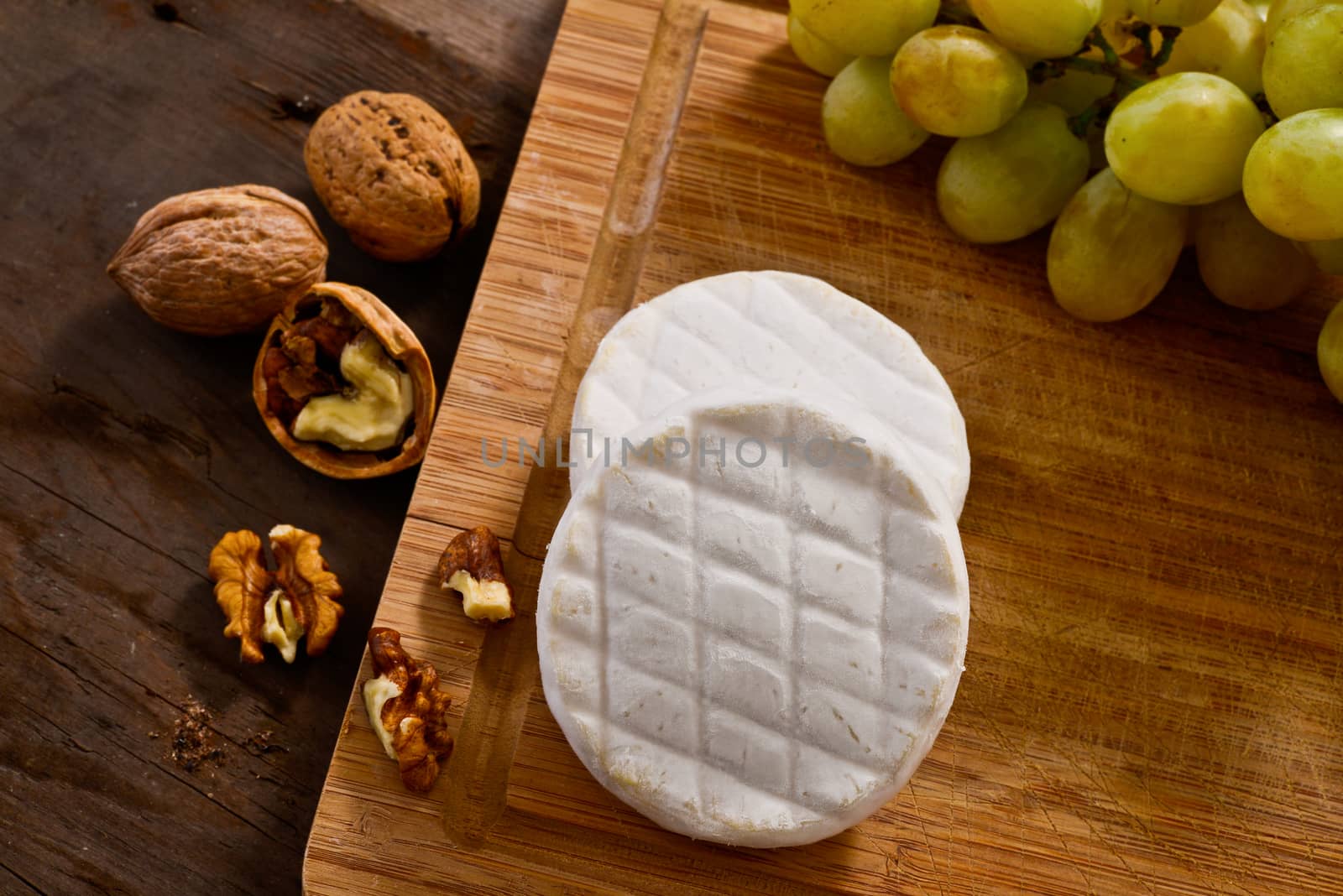 Italian tomino cheese on a wooden chopping board, italian appetizer