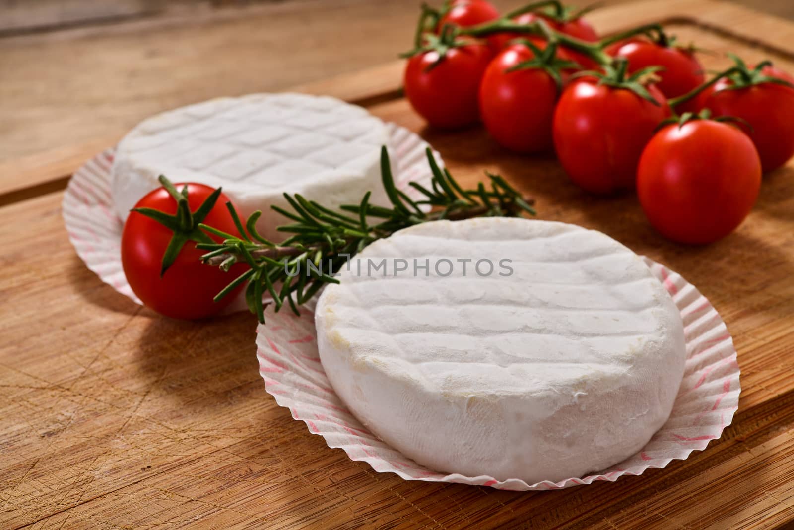 Italian tomino cheese on a wooden chopping board, italian appetizer