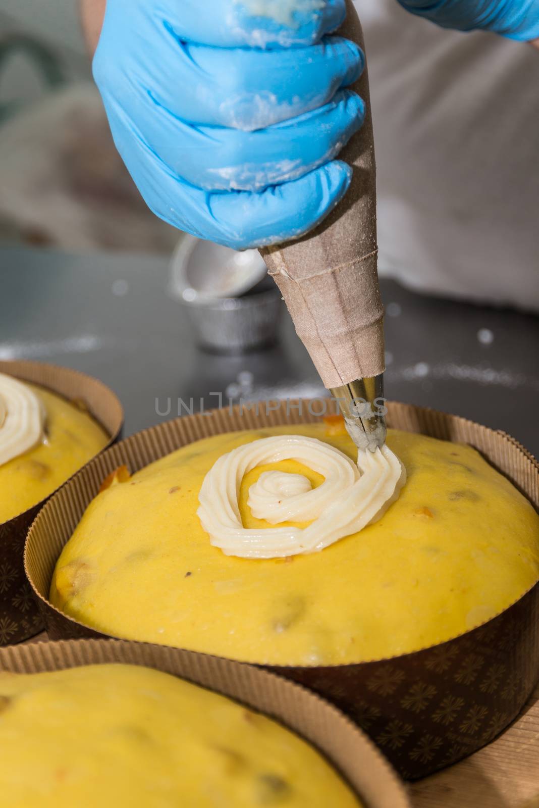 Pastry chef drops sugar icing on a panettone