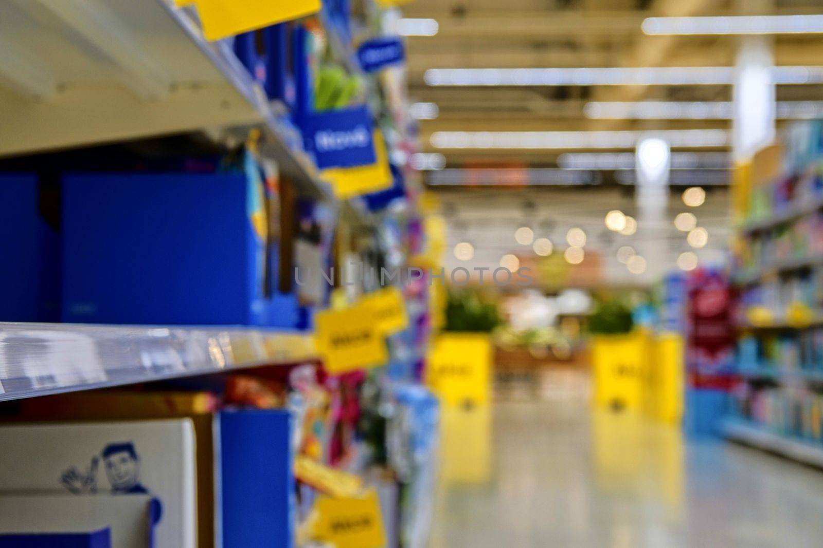 Blurred section at retail store in Europe. Aisle in local supermarket, defocused background.