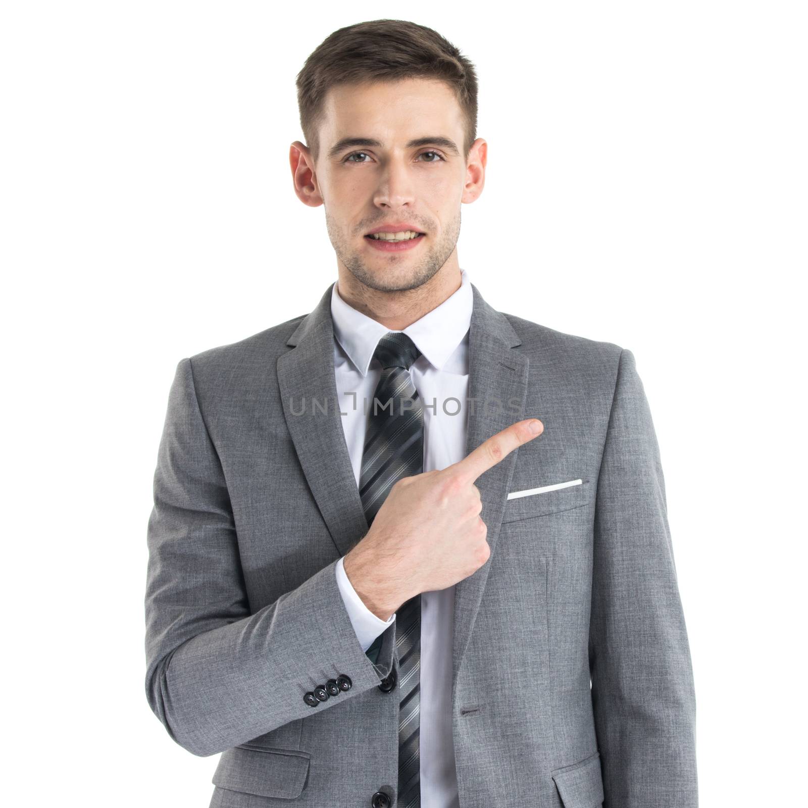 Portrait of young business man in suit pointing aside at copy space over white background