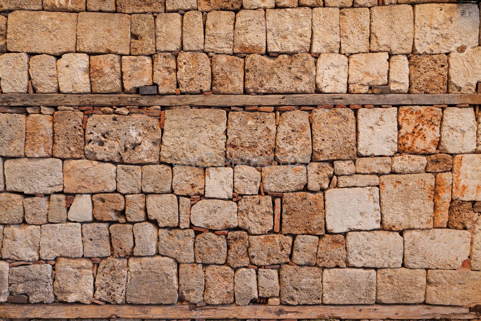 Background of stone fence wall of sandstone bricks