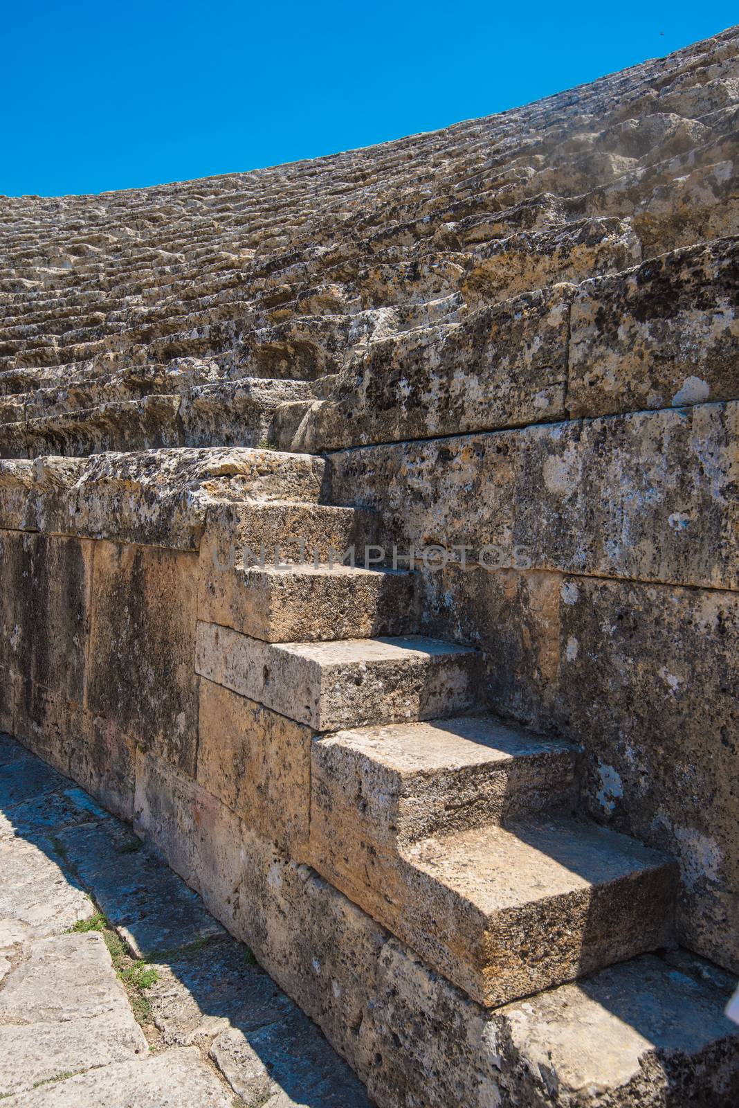 Closeup photo of steps of Roman amphitheatre in the ruins of Hierapolis, in Pamukkale, near modern turkey city Denizli, Turkey.