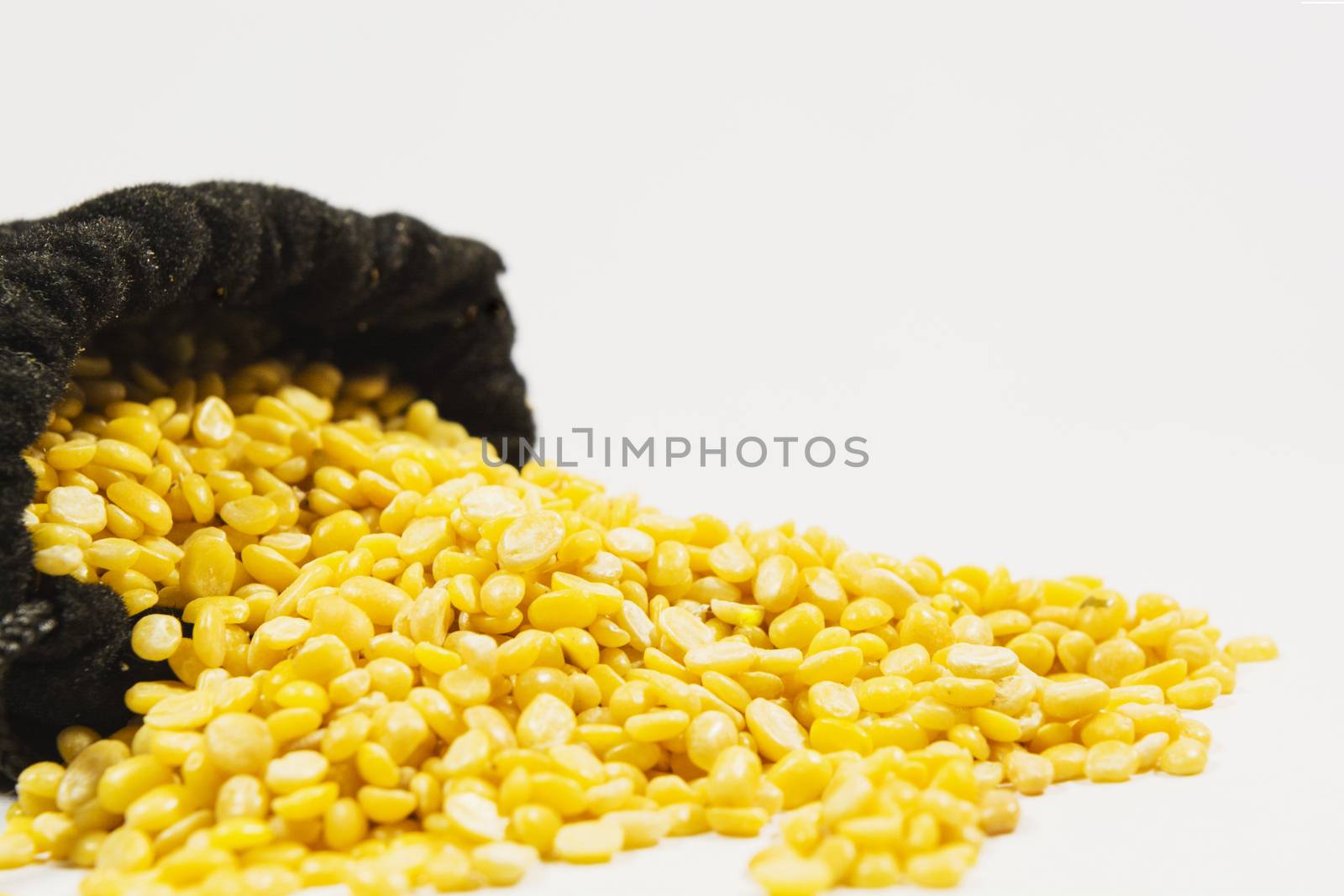 Split black grma seeds in black bag on isolated white background.
