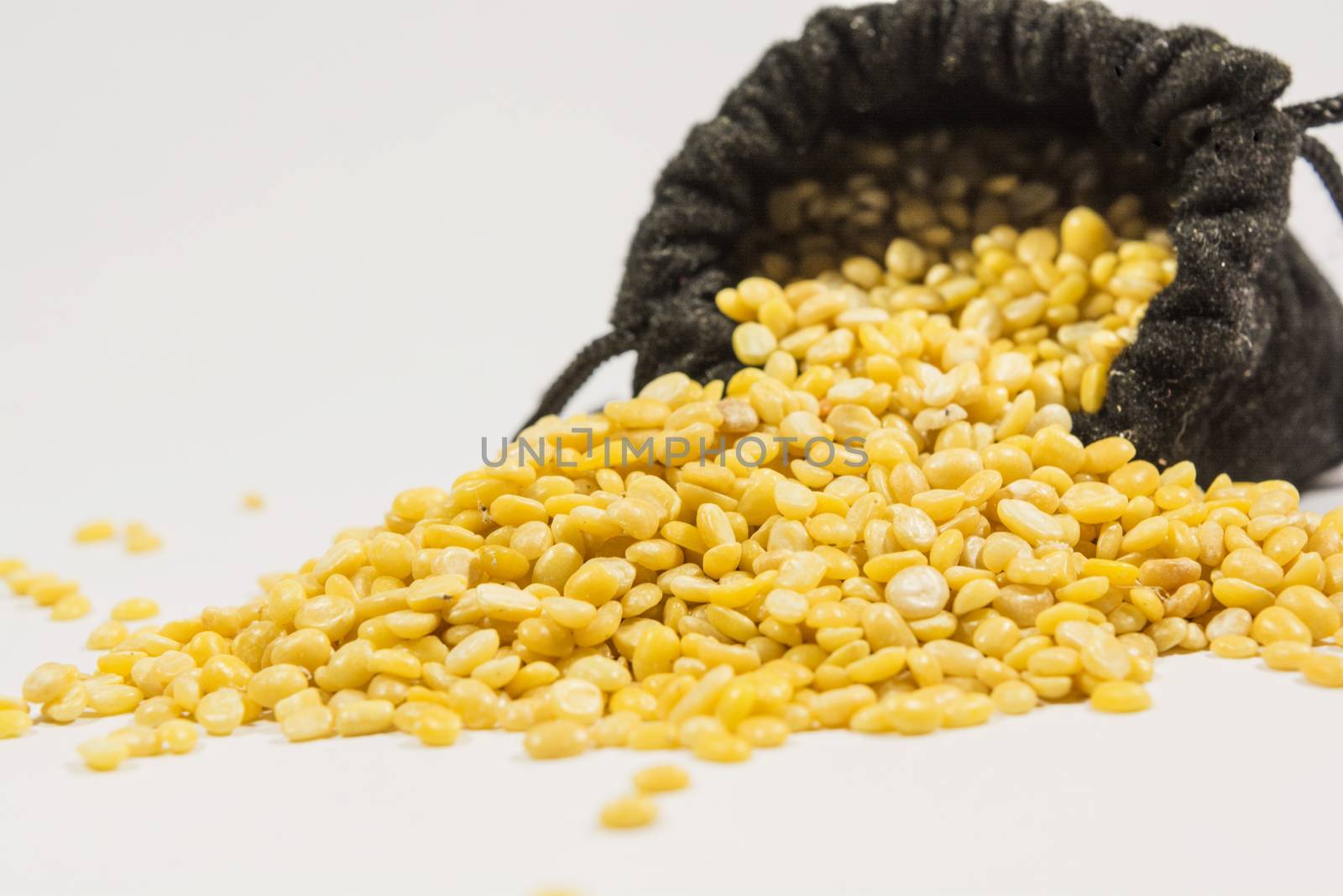 Split black grma seeds in black bag on isolated white background.