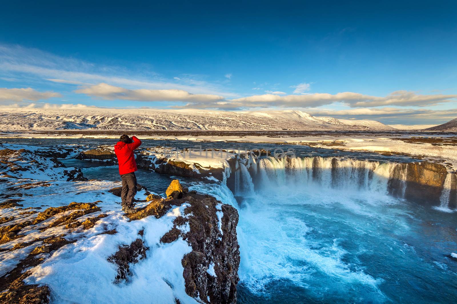 Photoghaper taking a photo at Godafoss waterfall in winter, Iceland. by gutarphotoghaphy