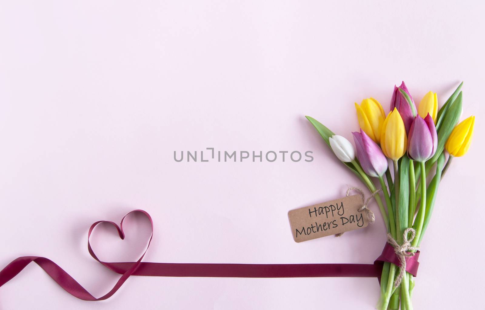 Heart shape ribbon attached to mothers day flowers with label
