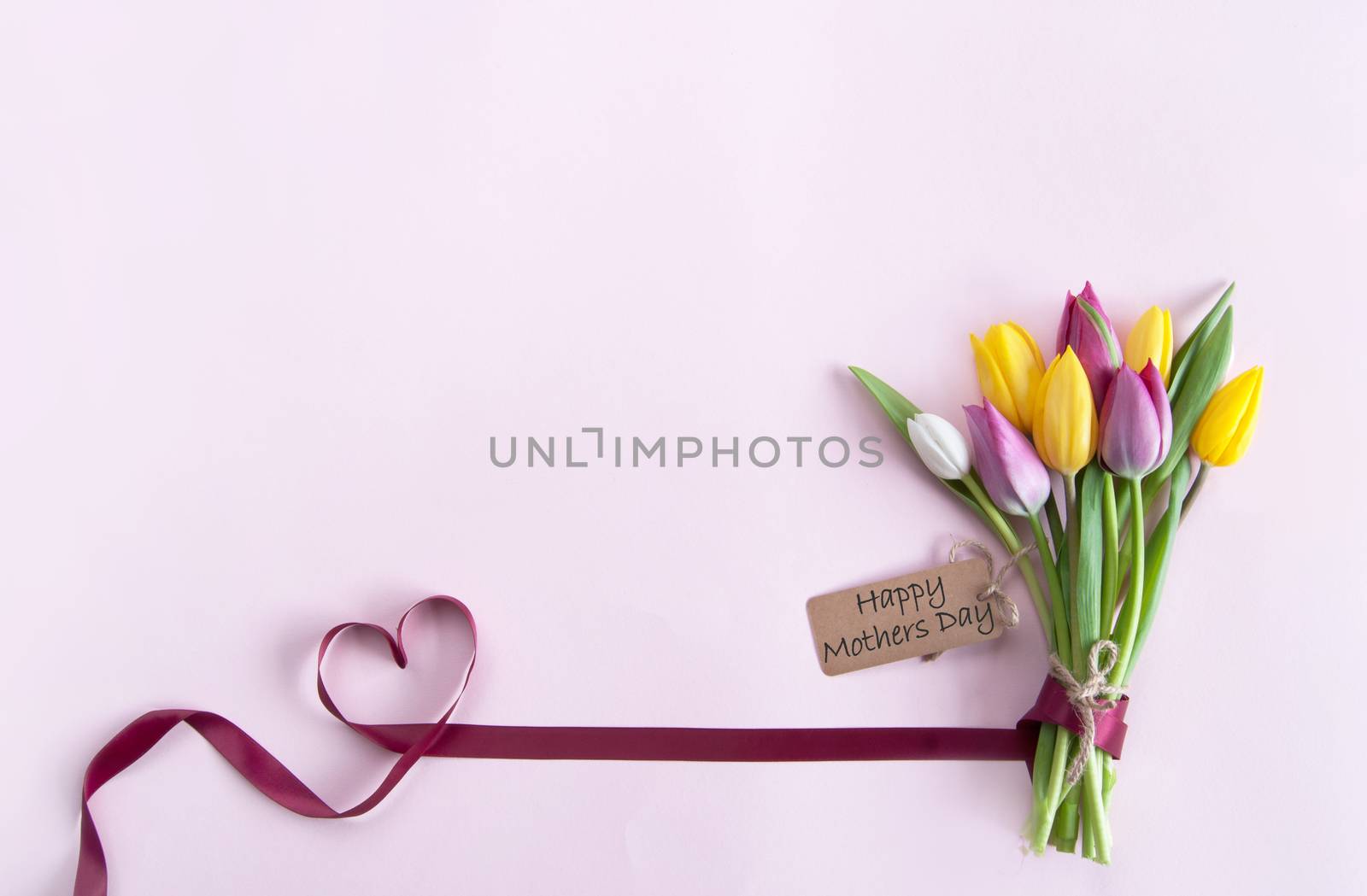 Heart shape ribbon attached to mothers day flowers with label