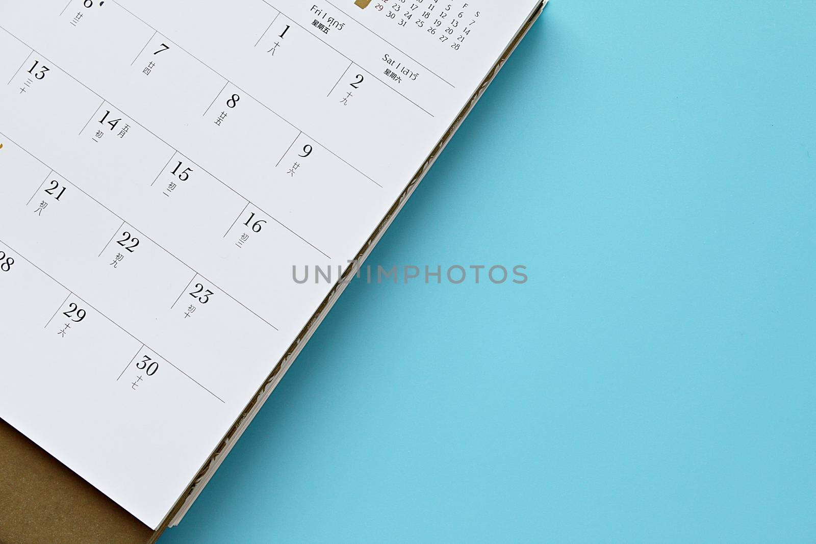 Top view or flat lay of calendar page on blue background by sureeporn