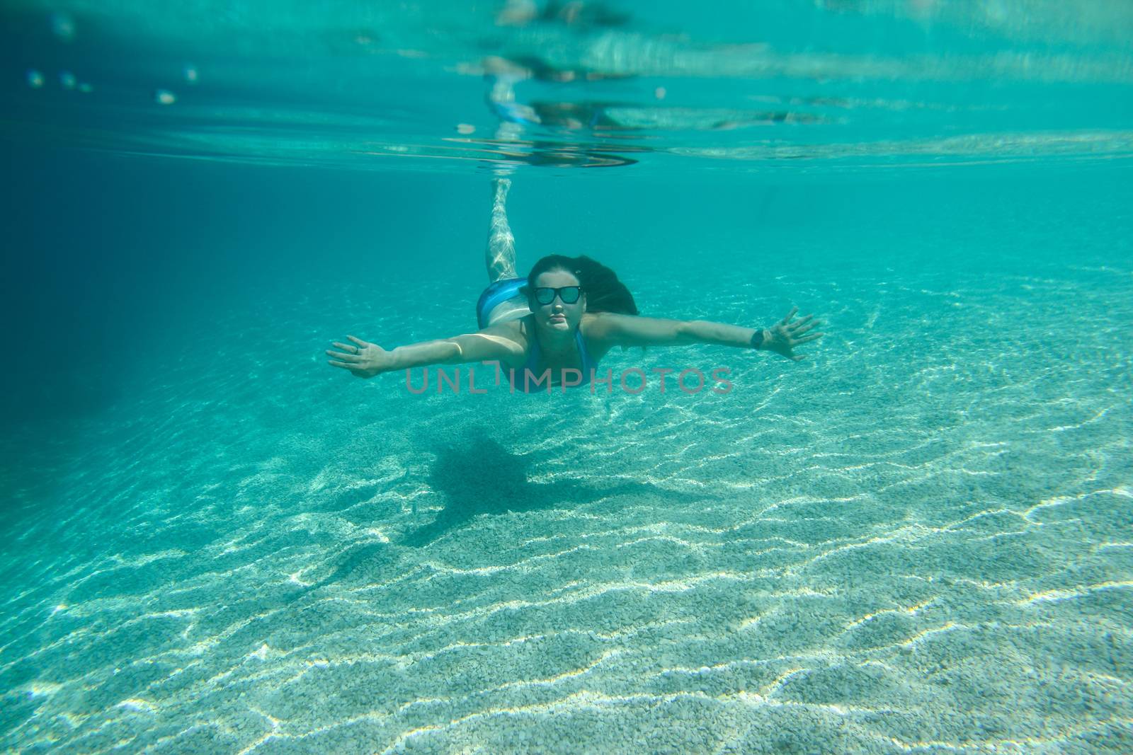 Woman swimming underwater, beautiful view of crystal clear transparent water of Mediterranean sea in Croatia