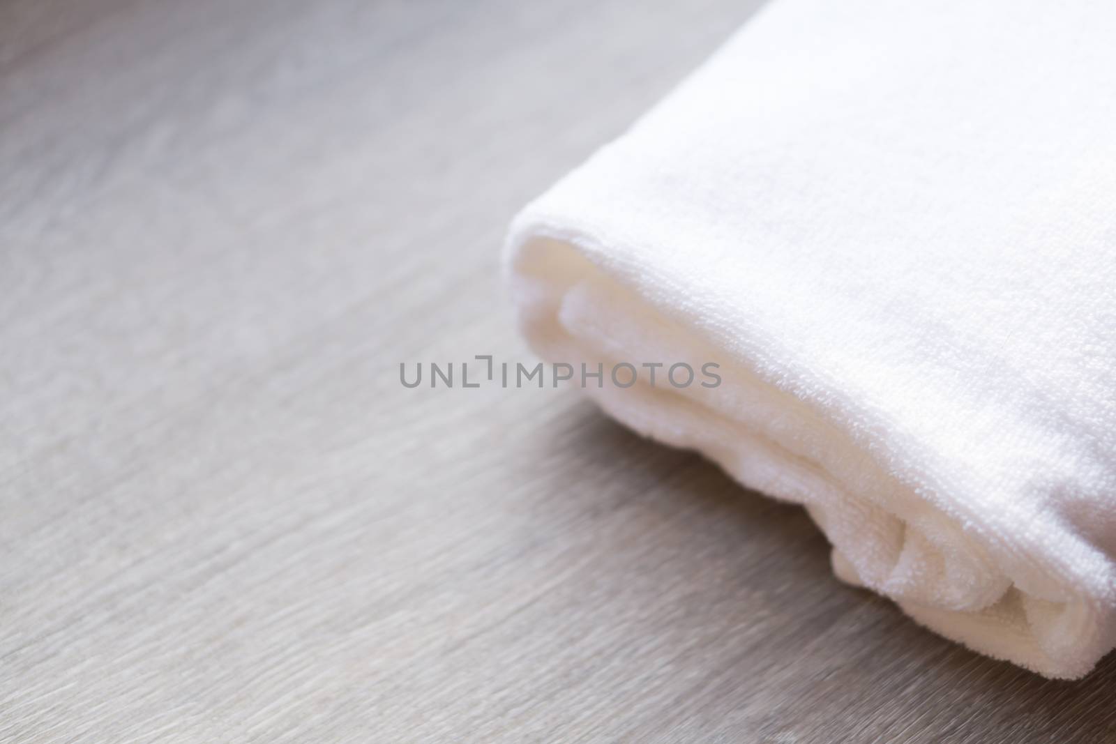 Closeup white towel on wood background, spa and relax concept, selective focus