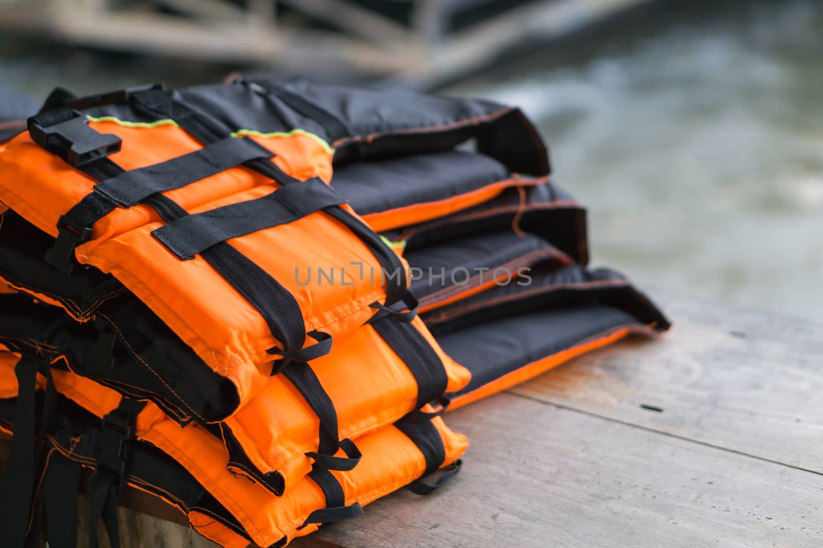 Closeup life jacket on wood table with river background, safety concept, selective focus