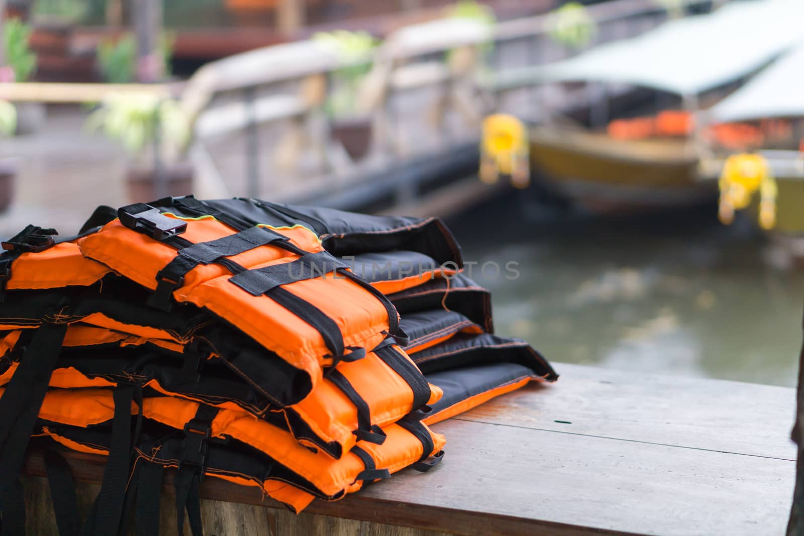 Closeup life jacket on wood table with river background, safety concept, selective focus