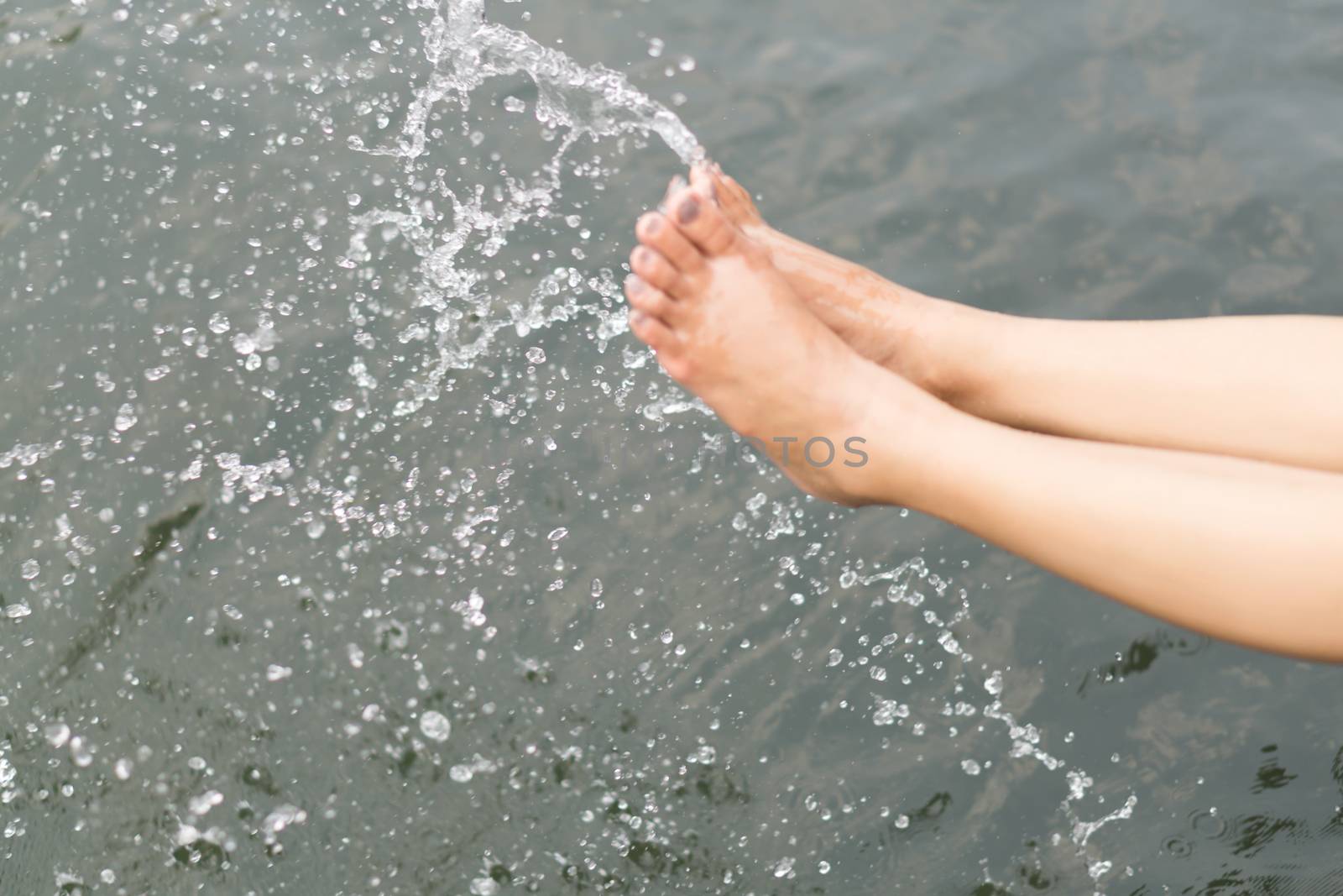 Closeup woman legs playing water with splashing for happy and relax concept, selective focus