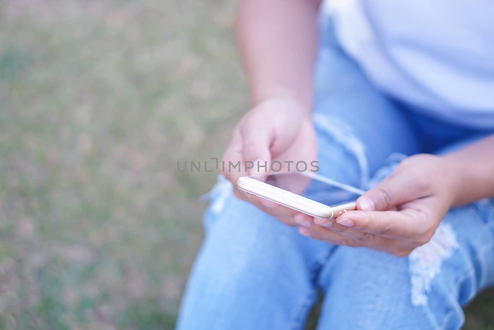 Closeup woman hand playing mobile phone with relaxing feelling, selective focus