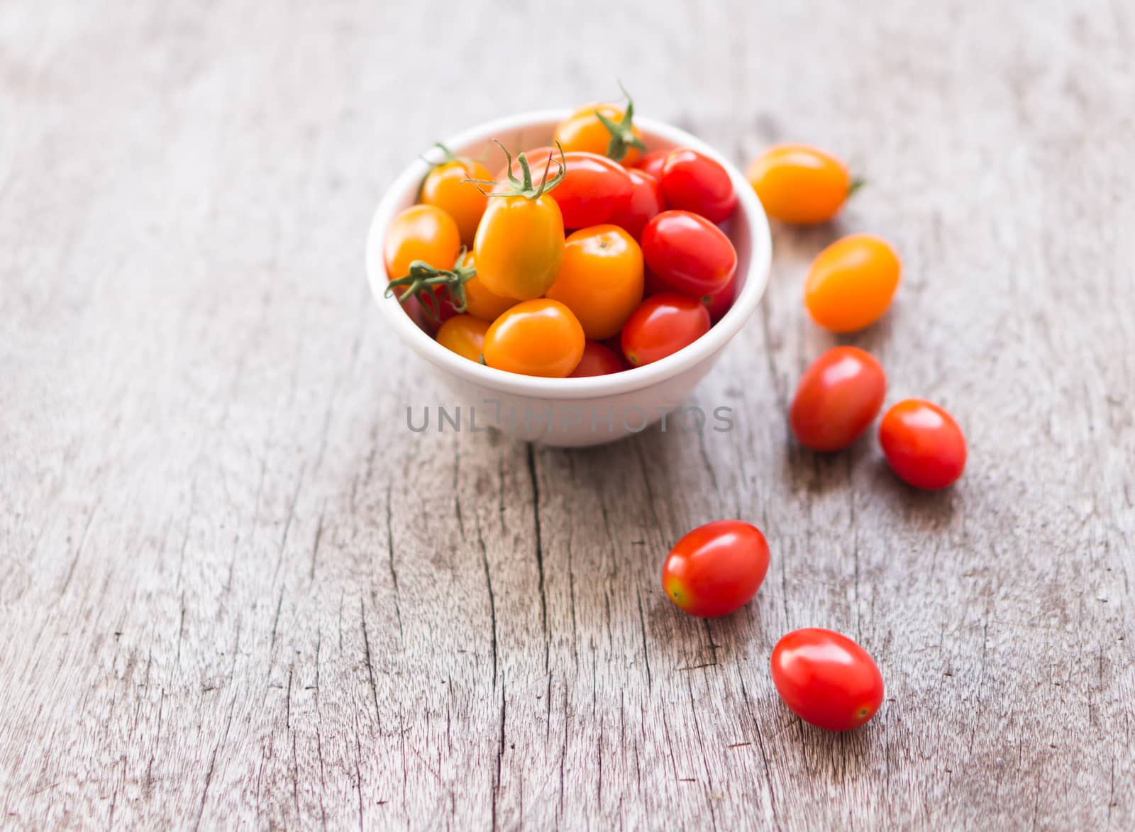 Fresh cherry tomatoes on wood background, raw food and vegetable, selective focus