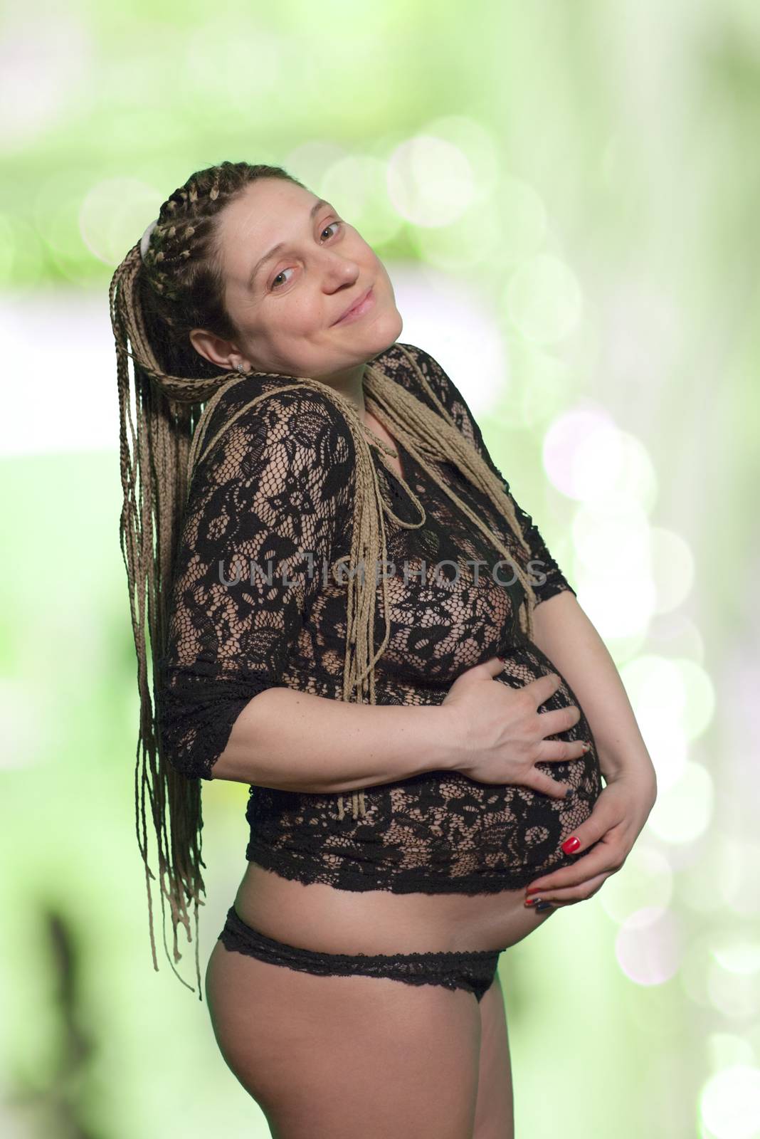 A beautiful pregnant woman holding her abdomen, isolated with work path.