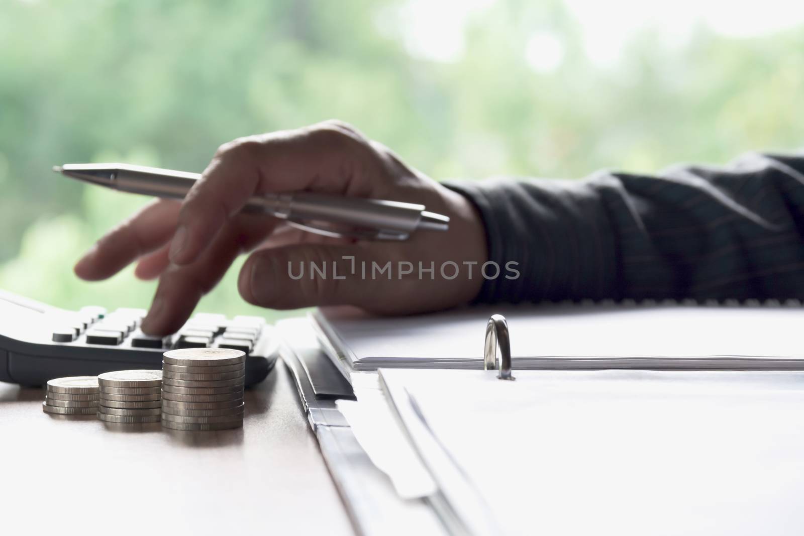 Man using calculator with stock financial indices with stack coin. Financial stock market in accounting market economy analysis.