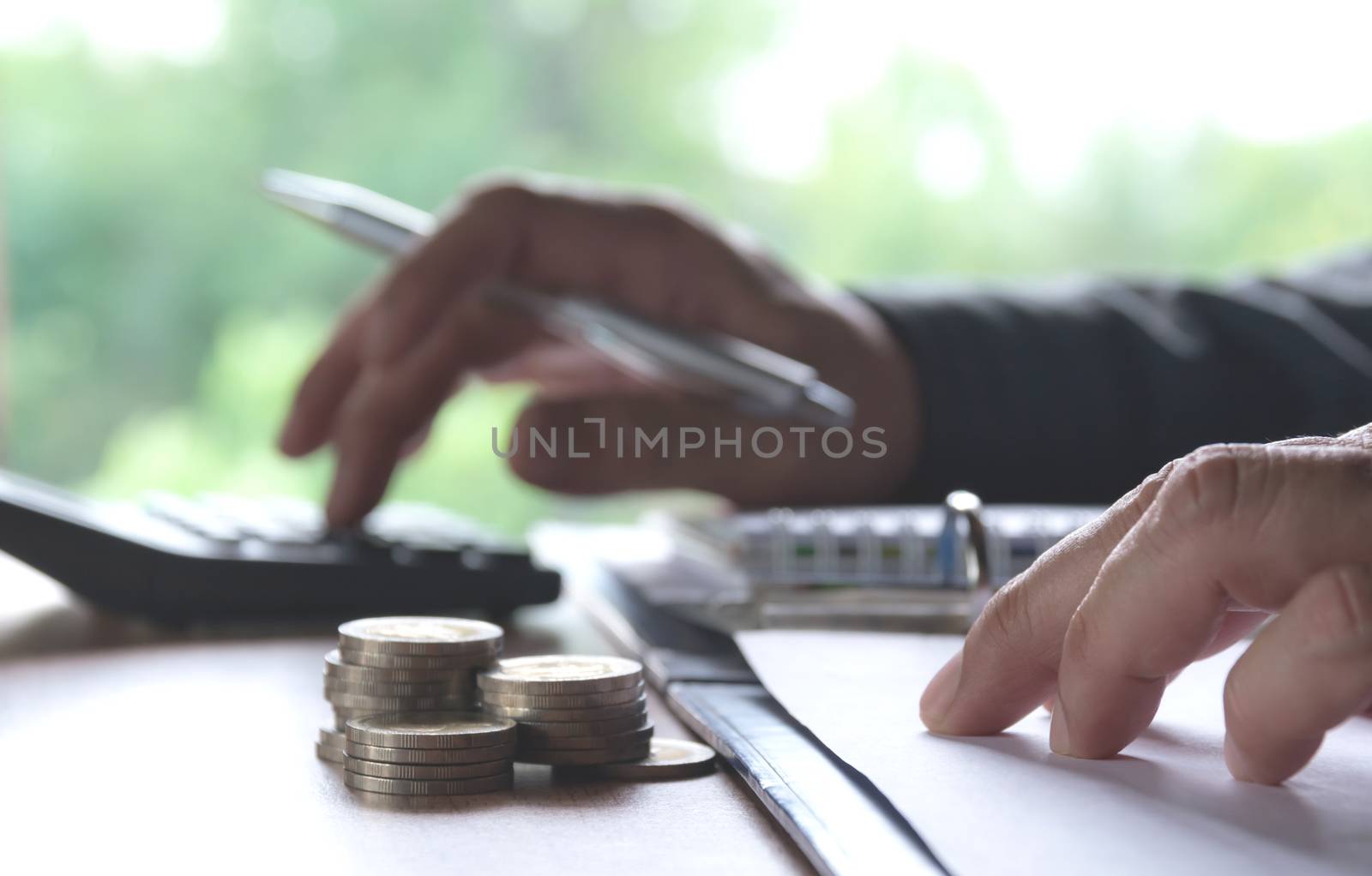 Man using calculator with stock financial indices with stack coin. Financial stock market in accounting market economy analysis.