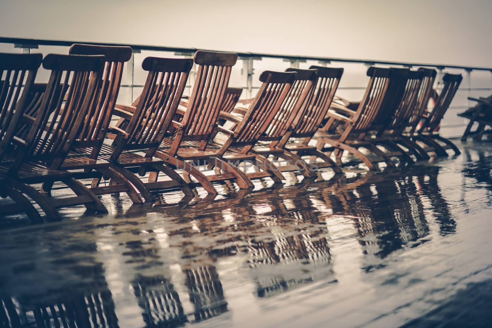 Rainy Cruise Vacation. Wet Main Wooden Deck and Deckchairs of the Cruise Ship. 