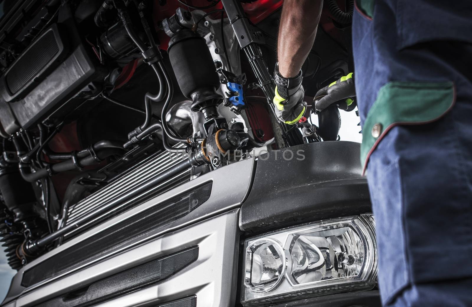 Modern Semi Truck Problem Diagnostic. Caucasian Truck Mechanic Doing His Best to Fix the Truck.