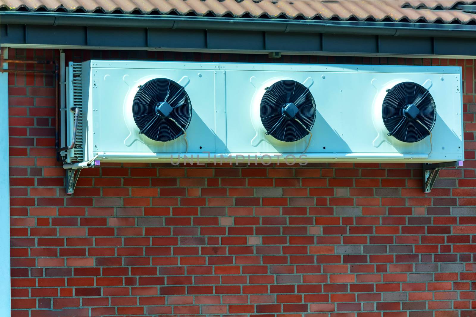 Compressor of an air conditioning mounted on a house wall.