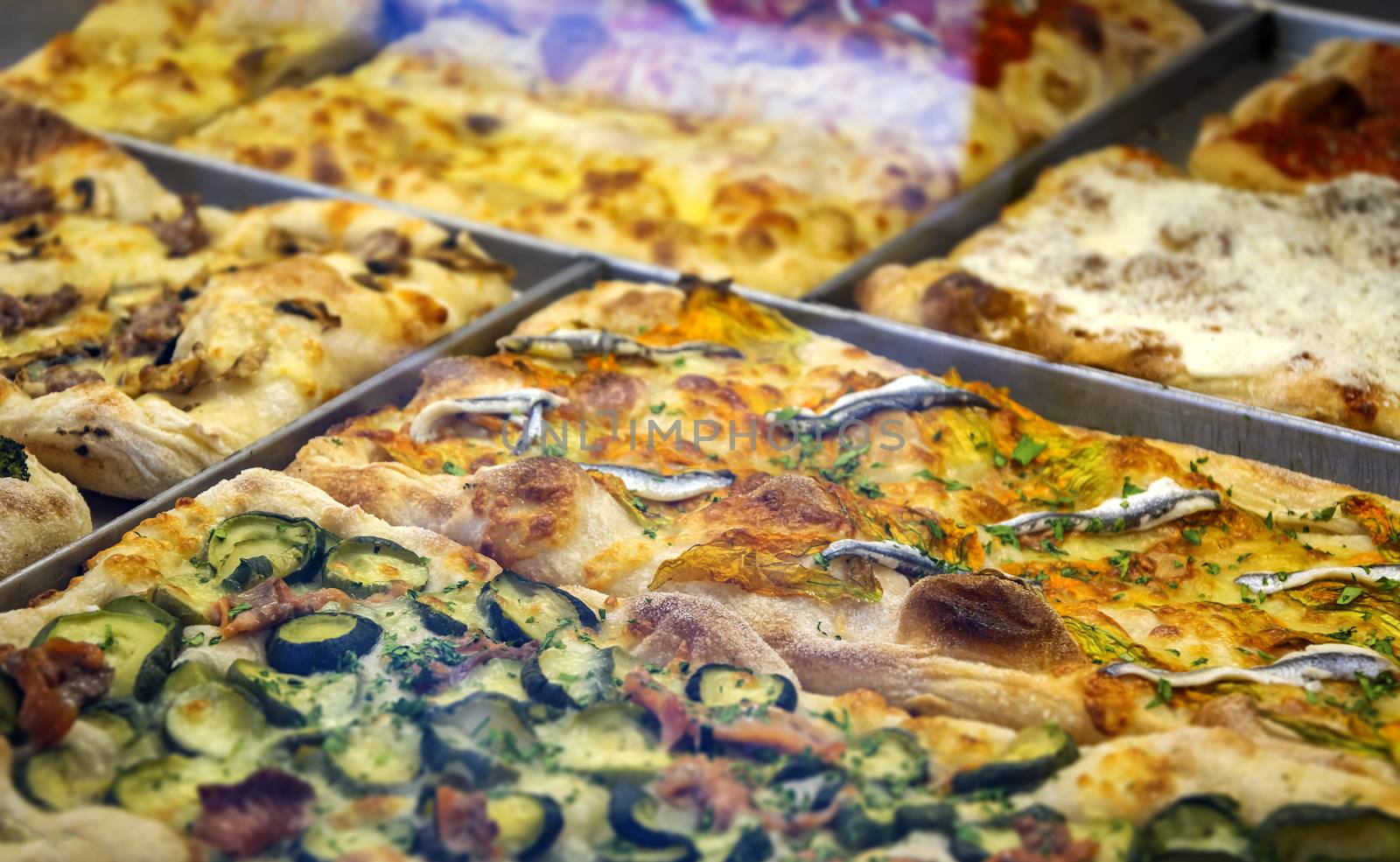 close-up view of a rectangular pizza slice stuffed with zucchini, anchovies and cheese